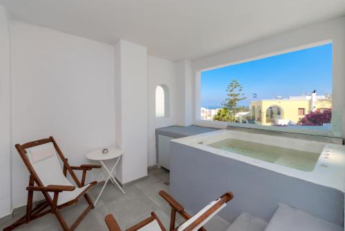 a white room with a large window and a tub at The Muses of Santorini Private Jacuzzi Suites in Vóthon