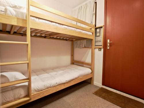 Pokój z łóżkiem piętrowym z 2 łóżkami piętrowymi i drzwiami w obiekcie Studio Chamrousse, 1 pièce, 6 personnes - FR-1-340-208 w mieście Chamrousse