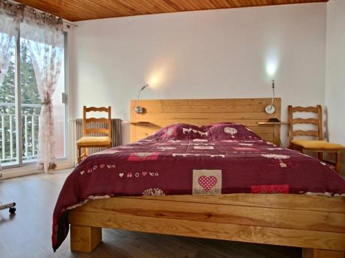 a bedroom with a wooden bed with a red bedspread at Appartement Chamrousse, 3 pièces, 6 personnes - FR-1-340-48 in Chamrousse