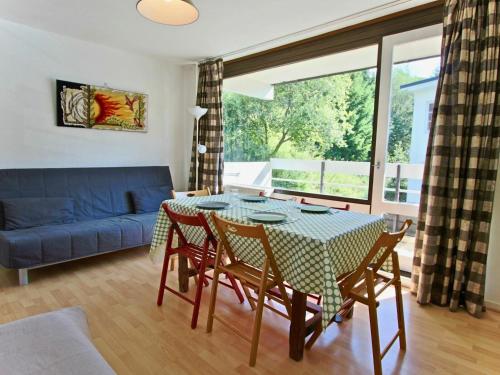 uma sala de estar com uma mesa e cadeiras e um sofá em Studio Chamrousse, 1 pièce, 3 personnes - FR-1-340-31 em Chamrousse