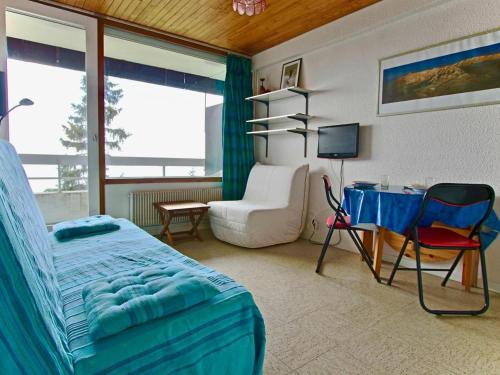 a bedroom with a bed and a desk and a chair at Studio Chamrousse, 1 pièce, 3 personnes - FR-1-340-92 in Chamrousse