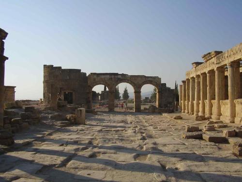 ancient ruins of a building with columns and archways at OzenTurku Hotel in Pamukkale