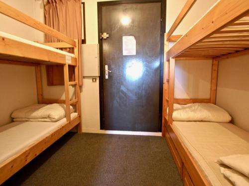 a room with two bunk beds and a door at Studio Chamrousse, 1 pièce, 6 personnes - FR-1-340-86 in Chamrousse