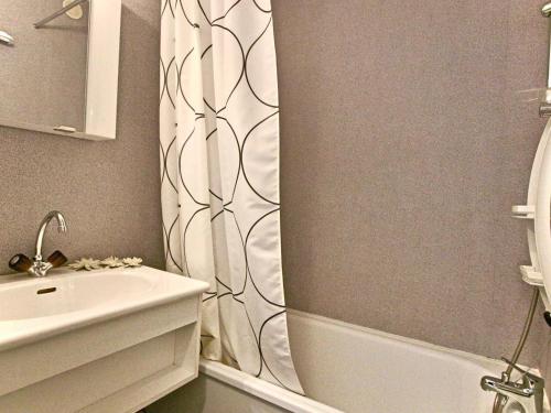 a bathroom with a shower curtain and a sink at Studio Chamrousse, 1 pièce, 4 personnes - FR-1-340-121 in Chamrousse