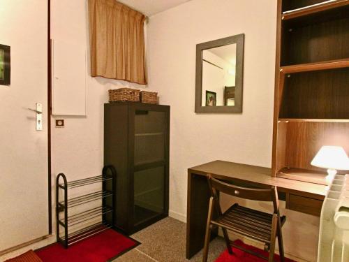シャンルッスにあるStudio Chamrousse, 1 pièce, 4 personnes - FR-1-340-121のデスク、椅子、鏡が備わる客室です。