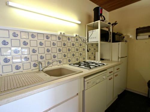 a kitchen with a sink and a stove and refrigerator at Appartement Chamrousse, 2 pièces, 6 personnes - FR-1-340-147 in Chamrousse