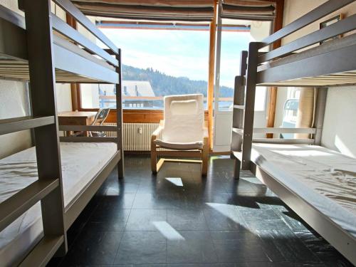 a room with several bunk beds and a chair at Appartement Chamrousse, 2 pièces, 6 personnes - FR-1-340-147 in Chamrousse