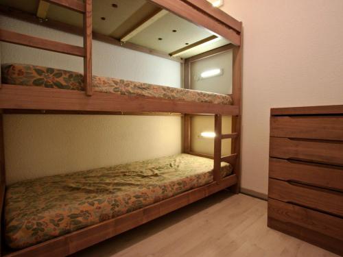 a bedroom with two bunk beds and a dresser at Appartement Chamrousse, 2 pièces, 6 personnes - FR-1-340-120 in Chamrousse