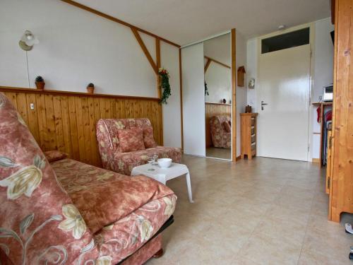 a living room with a couch and a chair at Studio Chamrousse, 1 pièce, 3 personnes - FR-1-340-135 in Chamrousse