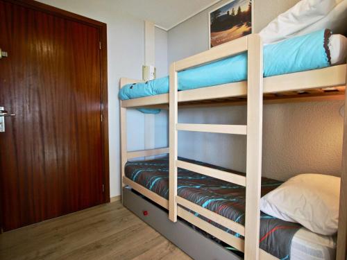 シャンルッスにあるAppartement Chamrousse, 2 pièces, 6 personnes - FR-1-340-157の二段ベッド2台とドアが備わる二段ベッドルーム1室を利用します。