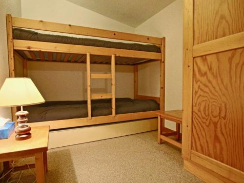 a bedroom with bunk beds with a lamp and a desk at Appartement Chamrousse, 2 pièces, 7 personnes - FR-1-340-229 in Chamrousse