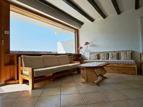 ein Wohnzimmer mit einem Sofa und einem Tisch in der Unterkunft Appartement Chamrousse, 3 pièces, 6 personnes - FR-1-340-204 in Chamrousse