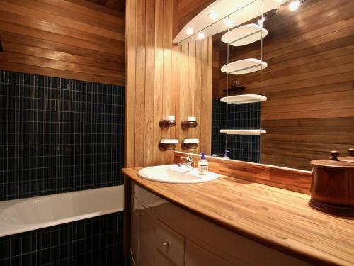 a bathroom with a sink and a mirror and a tub at Appartement Chamrousse, 3 pièces, 6 personnes - FR-1-340-204 in Chamrousse
