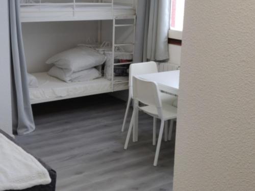 a room with a bed and a table and a bunk bed at Studio Chamrousse, 1 pièce, 4 personnes - FR-1-340-214 in Chamrousse