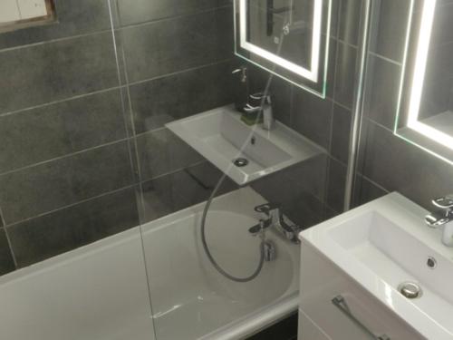 a bathroom with a shower and a sink and a tub at Studio Chamrousse, 1 pièce, 4 personnes - FR-1-340-214 in Chamrousse