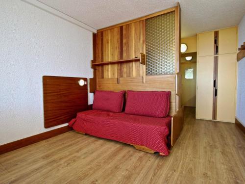 una sala de estar con un sofá rojo en una habitación en Studio Chamrousse, 1 pièce, 4 personnes - FR-1-549-38, en Chamrousse