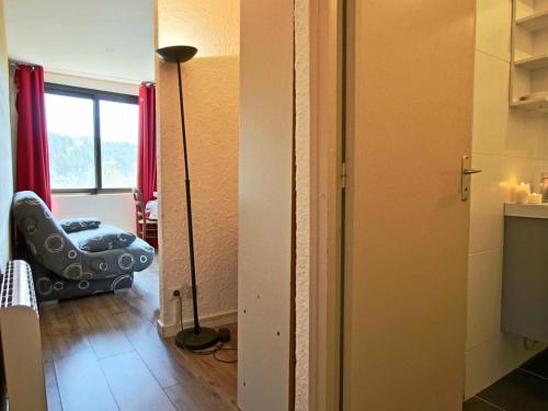 een kamer met een vloerlamp en een kamer met een stoel bij Studio Chamrousse, 1 pièce, 4 personnes - FR-1-340-218 in Chamrousse