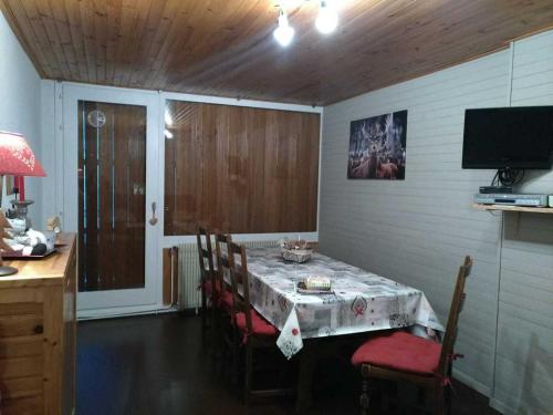 a dining room with a table and chairs and a television at Appartement Chamrousse, 2 pièces, 6 personnes - FR-1-549-54 in Chamrousse