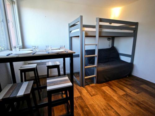 a room with a table and a bunk bed at Studio Chamrousse, 1 pièce, 3 personnes - FR-1-549-12 in Chamrousse