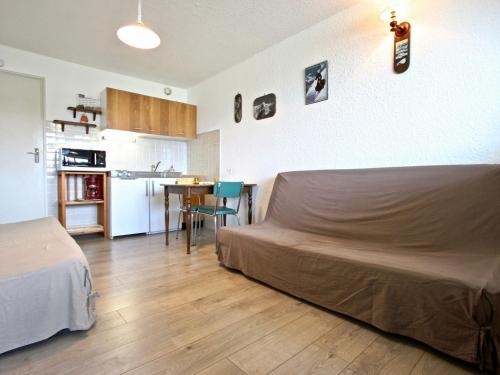 a bedroom with a bed and a kitchen with a table at Studio Chamrousse, 1 pièce, 3 personnes - FR-1-549-35 in Chamrousse