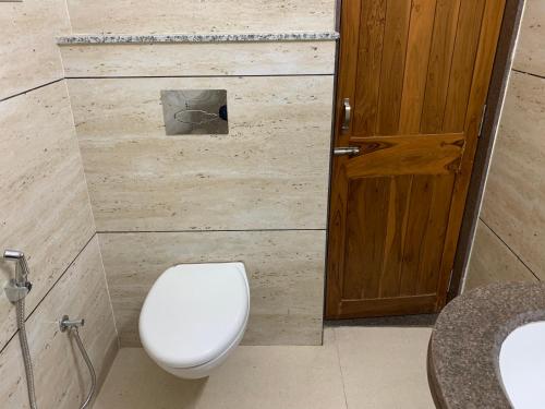 a bathroom with a toilet and a sink and a door at Hotel Mount Way in Ābu Road