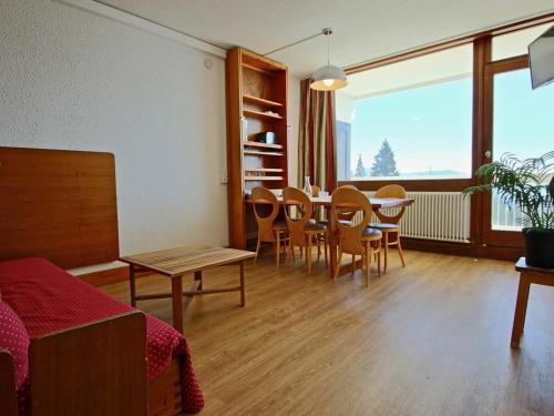 a living room with a dining room table and chairs at Studio Chamrousse, 1 pièce, 4 personnes - FR-1-549-33 in Chamrousse
