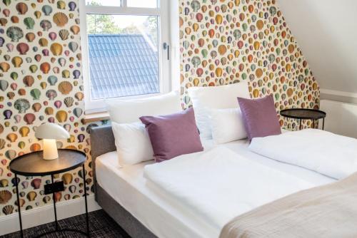 a bedroom with two beds and a window at Boutique Hotel Gezeiten SPO in Sankt Peter-Ording