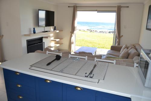 a kitchen with a view of the ocean at Hermanus Beach Club - St Tides House 19 in Hermanus