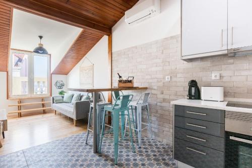 a kitchen with a table and chairs in a room at Graça Square Heritage Apartments by Tram 28 by NestAtLisbon in Lisbon