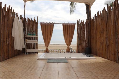 a bathroom with a tub and a wooden fence at Buena Vida Beach Resort in Morjim