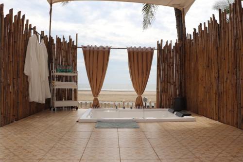 baño con bañera y valla de madera en Buena Vida Beach Resort, en Morjim
