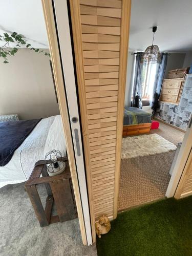 sypialnia z łóżkiem i drewnianymi drzwiami w obiekcie "Les Chaillottes" w mieście Chailles