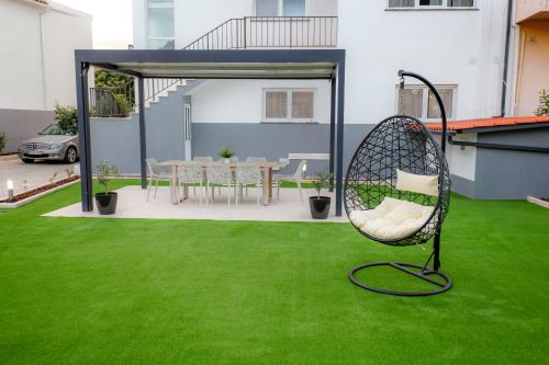 a chair sitting on a lawn in a yard at Cozy Apartment With Garden in Fátima