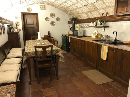 uma cozinha com uma mesa e um lavatório em La casa della sirena em SantʼEufemia a Maiella