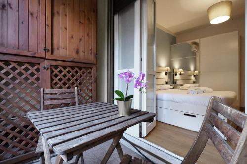 Zimmer mit einem Holztisch und einem Schlafzimmer in der Unterkunft PrimoPiano - Via Pavia in Mailand