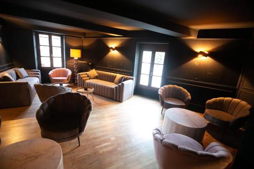 una sala de estar con sofás, mesas y ventanas en Hôtel La Batisse, en Crémieu