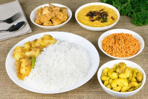 a table topped with white rice and bowls of food at The Rock Face in Ella