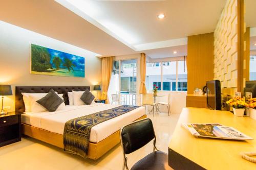 a hotel room with a large bed and a desk at Hallo Patong Hotel in Patong Beach