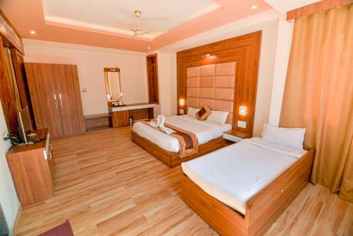 a hotel room with two beds and a television at Gold Nest Rubystone Heritage in Udaipur