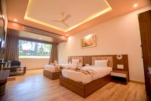 a bedroom with two beds and a ceiling fan at Gold Nest Rubystone Heritage in Udaipur