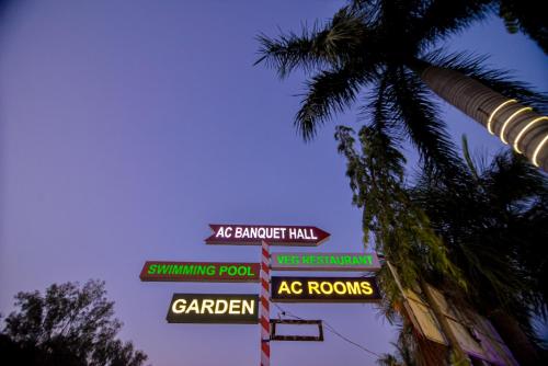 a bunch of street signs on a pole next to a palm tree at Gold Nest Rubystone Heritage in Udaipur
