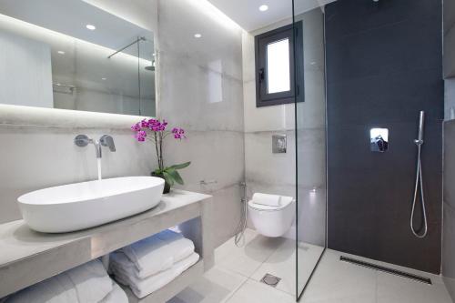 a bathroom with a sink and a shower and a toilet at Elysian villas in Palaiokatoúna