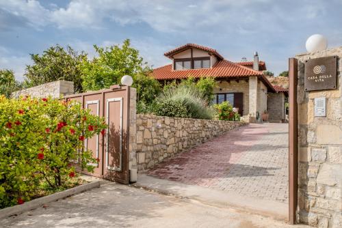 une porte menant à une maison dotée d'une clôture en pierre dans l'établissement Casa Della Vita Gouves Cretan Luxury Villa, à Gournes