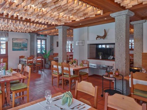 un restaurante con suelo de madera, mesas y sillas en Hotel Glocke, en Reckingen - Gluringen