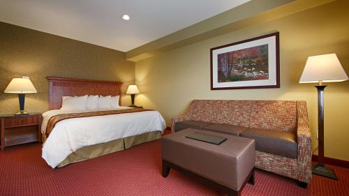 a hotel room with a bed and a couch at Best Western Plus Canyon Pines in Ogden