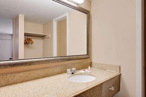 een badkamer met een wastafel en een grote spiegel bij Travelodge by Wyndham Ozona in Ozona