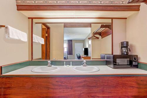 a bathroom with two sinks and a large mirror at Super 8 by Wyndham Albany in Albany