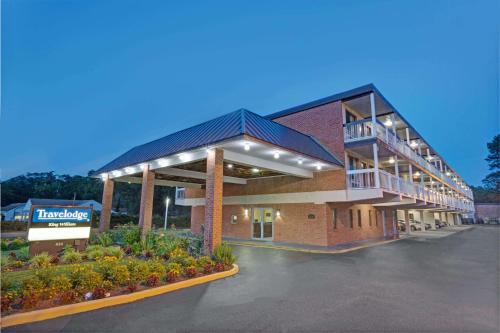 a large building with a parking lot in front of it at Travelodge by Wyndham Williamsburg Colonial Area in Williamsburg