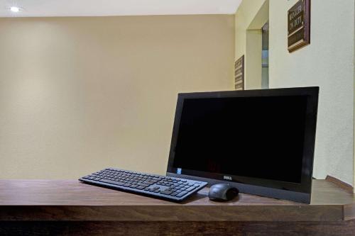 a computer monitor and a keyboard and mouse on a desk at Travelodge by Wyndham Williamsburg Colonial Area in Williamsburg