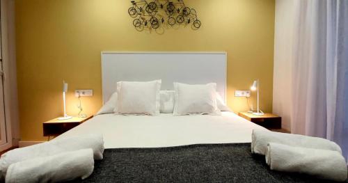 a bedroom with a large white bed with two lamps at Guesting Barrocal in Cádiz